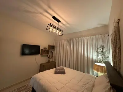 a bedroom with a bed and a television in it at Cozy Apartment Dubai Silicon Arch in Dubai