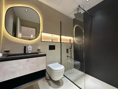 a bathroom with a toilet and a sink and a mirror at Cozy Apartment Dubai Silicon Arch in Dubai