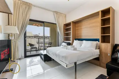 a bedroom with a bed and a balcony at Bookable- Studio Resortz By Danube with Balcony in Dubai