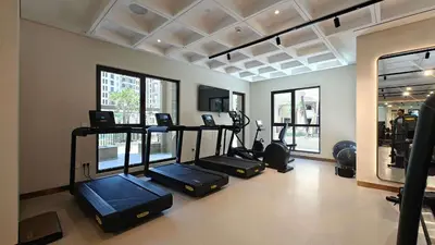 a gym with several elliptical machines in a room at StayShort - MJL Apartment for 2 people near Water Parks in Dubai