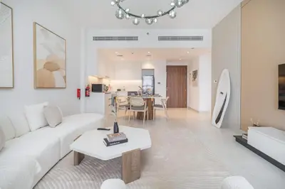 a living room with a white couch and a table at StayShort - MJL Apartment for 2 people near Water Parks in Dubai