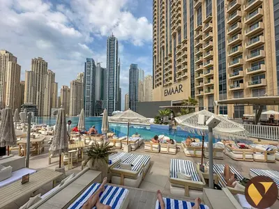 a pool with chaise lounges and a city skyline at Vogue Marina JW Marriott with Direct Access to Marina Mall, Studio Apartment with Balcony and Marina Skyline View, Access to all Amenities in Dubai