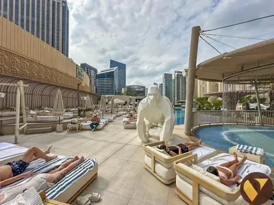 a resort with a pool and people laying on beds at Vogue Marina JW Marriott with Direct Access to Marina Mall, Studio Apartment with Balcony and Marina Skyline View, Access to all Amenities in Dubai