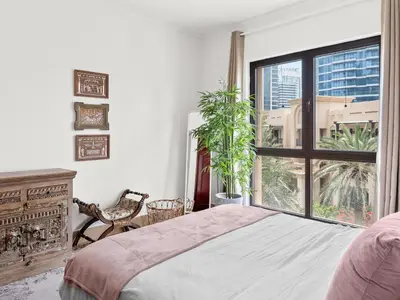 a bedroom with a bed and a large window at Spacious 2BR Steps from Downtown in Dubai