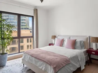 a bedroom with a large bed and a large window at Spacious 2BR Steps from Downtown in Dubai