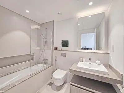 a bathroom with a sink and a toilet and a shower at Deluxe 1-Bedroom in The Grand - Waterfront and Skyline Views in Dubai