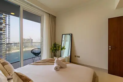 a bedroom with a bed and a large window at Lux and Spacious 1 Bed with Beach in Dubai