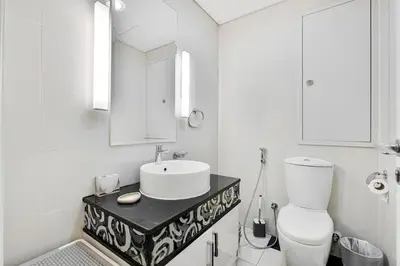a white bathroom with a sink and a toilet at Elegant 2BR APT, 3 minutes to Burj Khalifa in Dubai