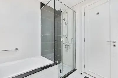 a shower with a glass door in a bathroom at Elegant 2BR APT, 3 minutes to Burj Khalifa in Dubai