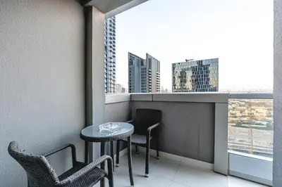 a balcony with a table and chairs and a window at Elegant 2BR APT, 3 minutes to Burj Khalifa in Dubai
