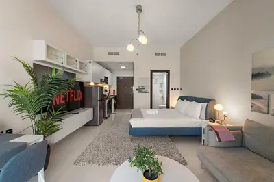 a living room with a bed and a couch at Luxury Studio with Gym, Pool & Badminton Court in Dubai