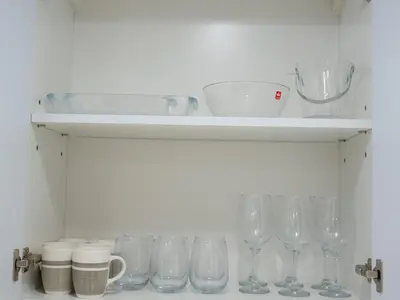 a shelf with wine glasses and cups on it at Binghatti Crest in Dubai
