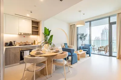 a kitchen and living room with a table and chairs at Incredibly Elegant 1BDR with full Marina Views in Dubai