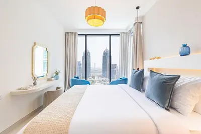 a white bedroom with a large bed and a window at Incredibly Elegant 1BDR with full Marina Views in Dubai
