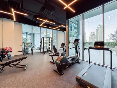 a gym with treadmills and ellipticals in a room with windows at Incredibly Elegant 1BDR with full Marina Views in Dubai