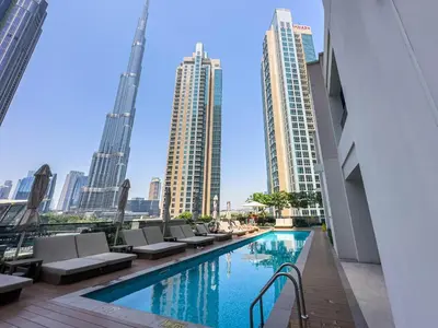 a view of a pool in a city with tall buildings at Beautiful 2BR with Burj Khalifa Views in Dubai