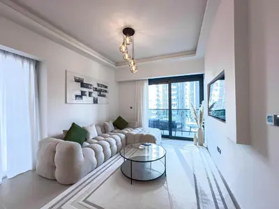 a living room with a white couch and a glass table at Beautiful 2BR with Burj Khalifa Views in Dubai