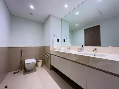 a bathroom with two sinks and a toilet and a mirror at Beautiful 2BR with Burj Khalifa Views in Dubai