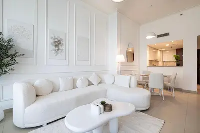 a white living room with a white couch and a table at Luxury Burj Vista Suites by Mystique - Breathtaking Burj Khalifa Views in Dubai