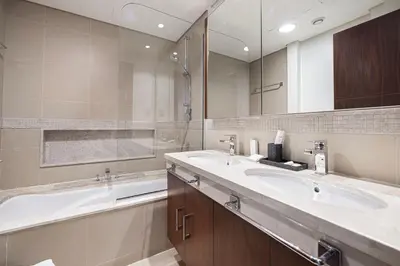 a bathroom with two sinks and a bath tub at Luxury Burj Vista Suites by Mystique - Breathtaking Burj Khalifa Views in Dubai