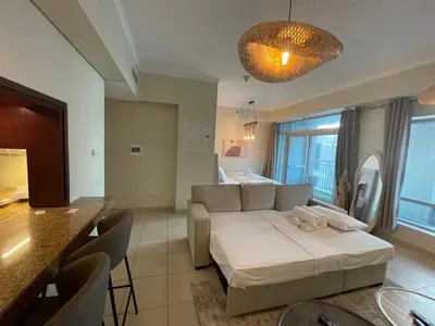 a living room with a couch and a table at Cozy Studio Near Burj Khalifa Sleeps 3 in Dubai