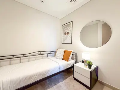 a bedroom with a bed and a mirror at Act 1 Act 2 Towers, Luxury 4BR, Full Burj Khalifa View Balcony, Pool, Gym in Dubai