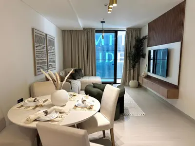 a living room with a table and chairs and a couch at Binghatti Galaxy 2 in Dubai