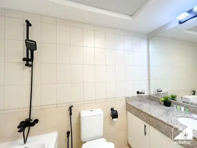a bathroom with a toilet and a sink and a mirror at Stylish JVC Duplex l Gym, Pool & Parking in Dubai
