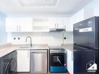 a kitchen with a stove and a sink and a refrigerator at Stylish JVC Duplex l Gym, Pool & Parking in Dubai