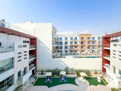 an apartment with a swimming pool and two buildings at Stylish JVC Duplex l Gym, Pool & Parking in Dubai