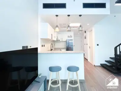 a kitchen with two stools at a counter at Urban Duplex Hideaway l Gym, Pool & Balcony in Dubai