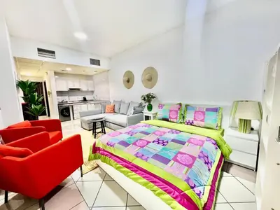 a bedroom with a bed and a red chair at Sleep 6 Mina Road in Dubai