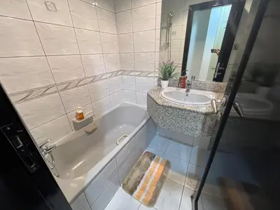 a bathroom with a bath tub and a sink at Sleep 6 Mina Road in Dubai