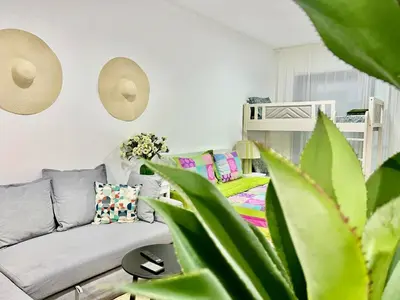 a living room with a couch and a bed at Sleep 6 Mina Road in Dubai