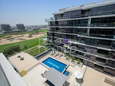 an aerial view of a building with a swimming pool at Modern 2BR Gem Full Golf Views & Pool in Dubai