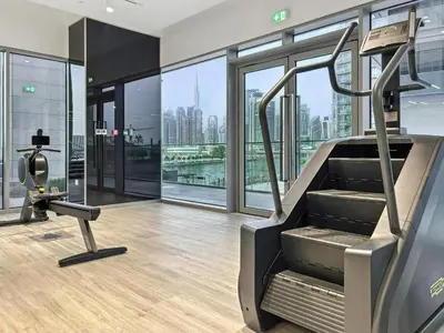 a gym with a treadmill and views of the city at 2BR plus Maid CF7 B Stylish Stay with Large Balcony in Dubai