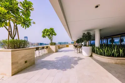 a balcony with chairs and plants on a building at Sea Breeze apartment in Grand Bleu - private Beach in Dubai