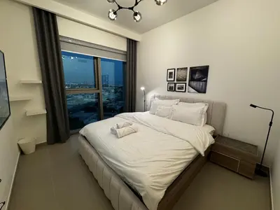 a bedroom with a large white bed with a window at 2min Walk to Dubai Mall - 2BR - Infinity Pool & Gym - Burj Khalifa in Dubai