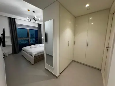 a bedroom with a mirror and a bed and a window at 2min Walk to Dubai Mall - 2BR - Infinity Pool & Gym - Burj Khalifa in Dubai