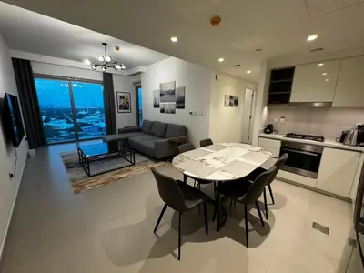 a kitchen and living room with a table and chairs at 2min Walk to Dubai Mall - 2BR - Infinity Pool & Gym - Burj Khalifa in Dubai