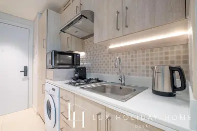 a small kitchen with a sink and a microwave at LUX The Seven Res Palm Studio in Dubai