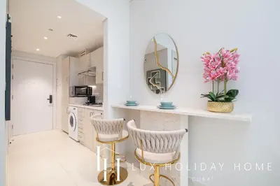 a kitchen with a mirror and two chairs at LUX The Seven Res Palm Studio in Dubai
