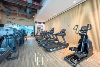 a gym with treadmills and ellipticals in a room at LUX The Seven Res Palm Studio in Dubai