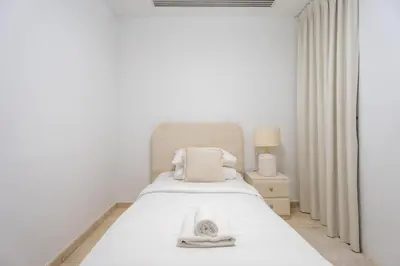 a white bedroom with a bed and a window at GuestReady - Luxury 2BD w/ balcony | Business Bay in Dubai