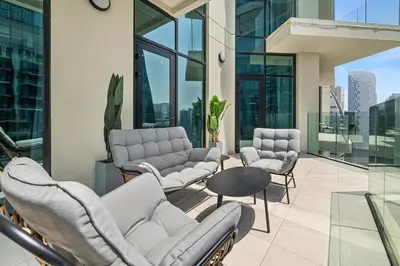 a living room with couches and chairs on a balcony at BLVD - Missoni Canal View - Walk to Dubai Mall in Dubai