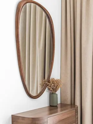 a round mirror on a wall next to a curtain at Upscale 2Bedroom with Private Balcony Pool in JVC in Dubai