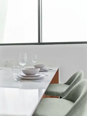 a dining table with glasses and plates and chairs at Upscale 2Bedroom with Private Balcony Pool in JVC in Dubai