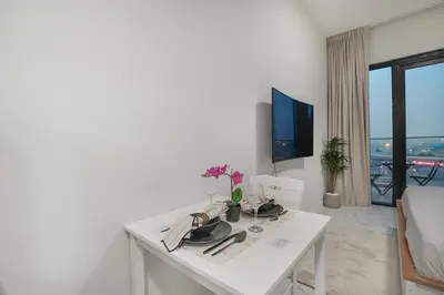 a living room with a white table and a tv at EasyGo- Comfy, near metro, Easy Access to City Roads in Dubai