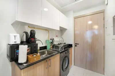 a kitchen with a sink and a washing machine at EasyGo- Comfy, near metro, Easy Access to City Roads in Dubai