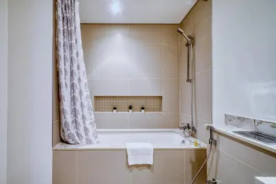 a bathroom with a tub and a shower at Relax & Unwind with Dubai Creek Vibes in Dubai